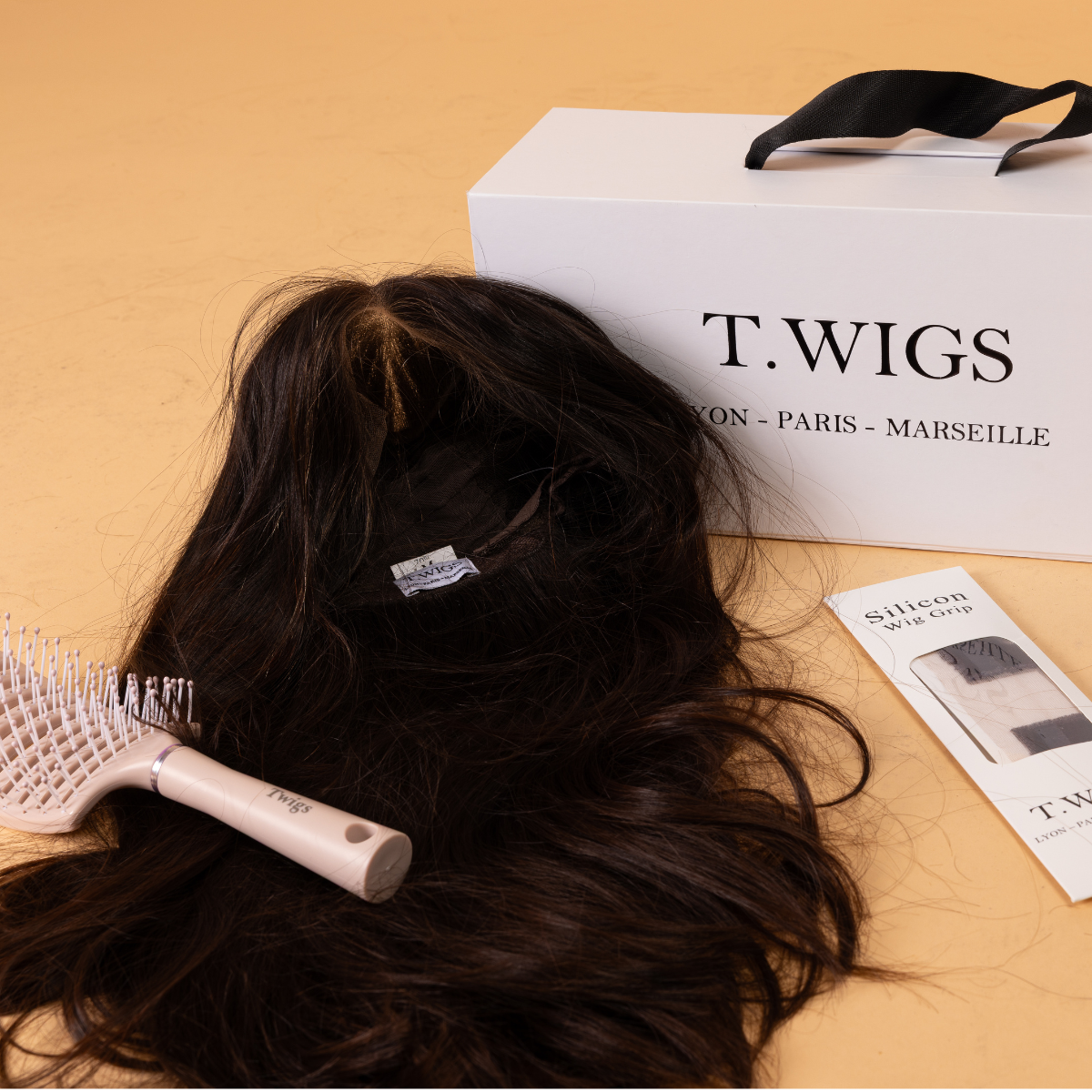 une boîte de voyage, un bandeau antiglisse et une brosse à perruque